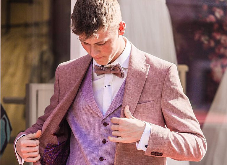 Bräutigam trägt Hochzeitsanzüge in Beerentönen